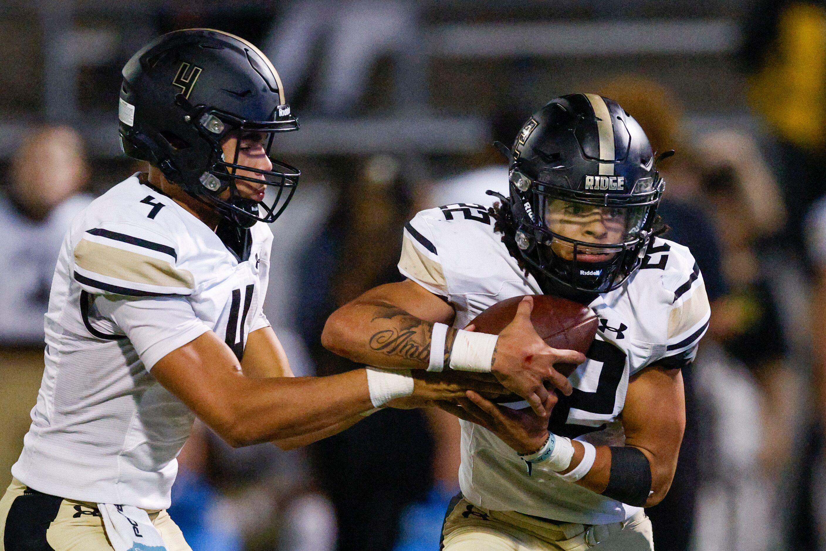 Keller Fossil Ridge quarterback Logan Cundiff (4) hands the ball to running back Cameron...