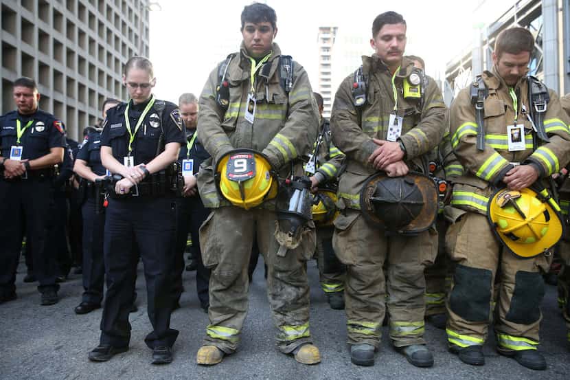 Police officers, firefighters and EMS bow in a moment of silence prior to The 9/11 Memorial...
