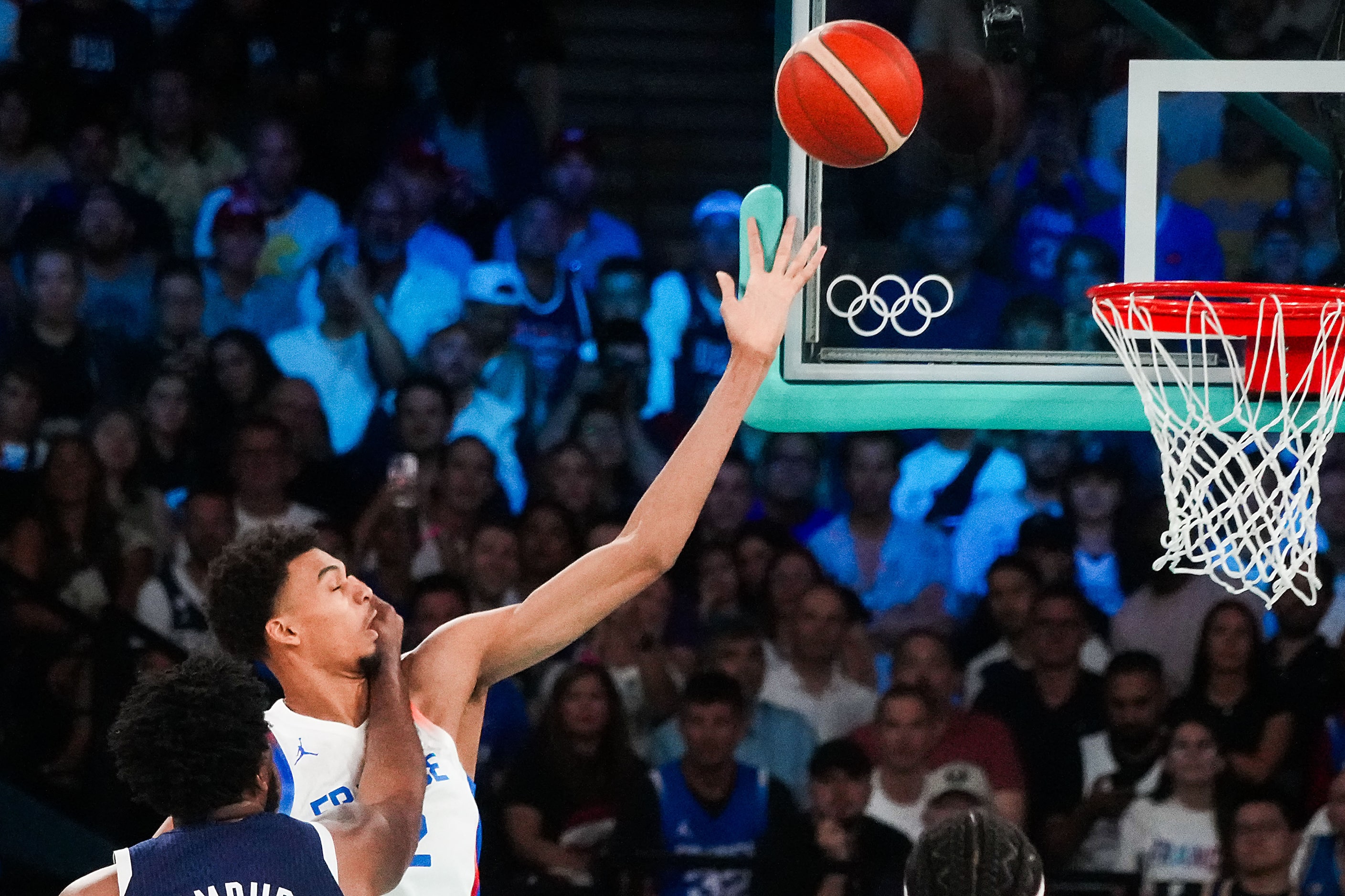 Victor Wembanyama (32) of France scores past Joel Embiid (11) of the United States during...