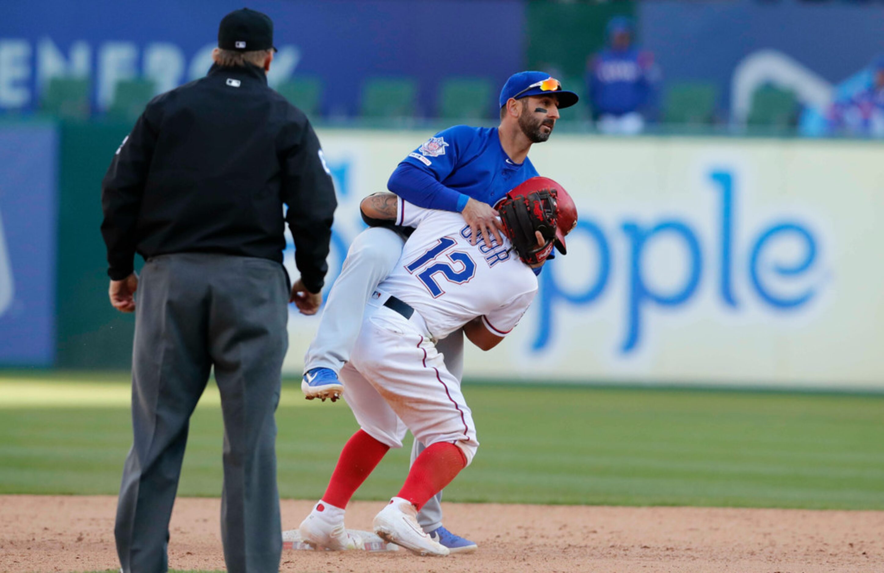 Chicago Cubs second baseman Daniel Descalso, top center, is embraced by Texas Rangers'...