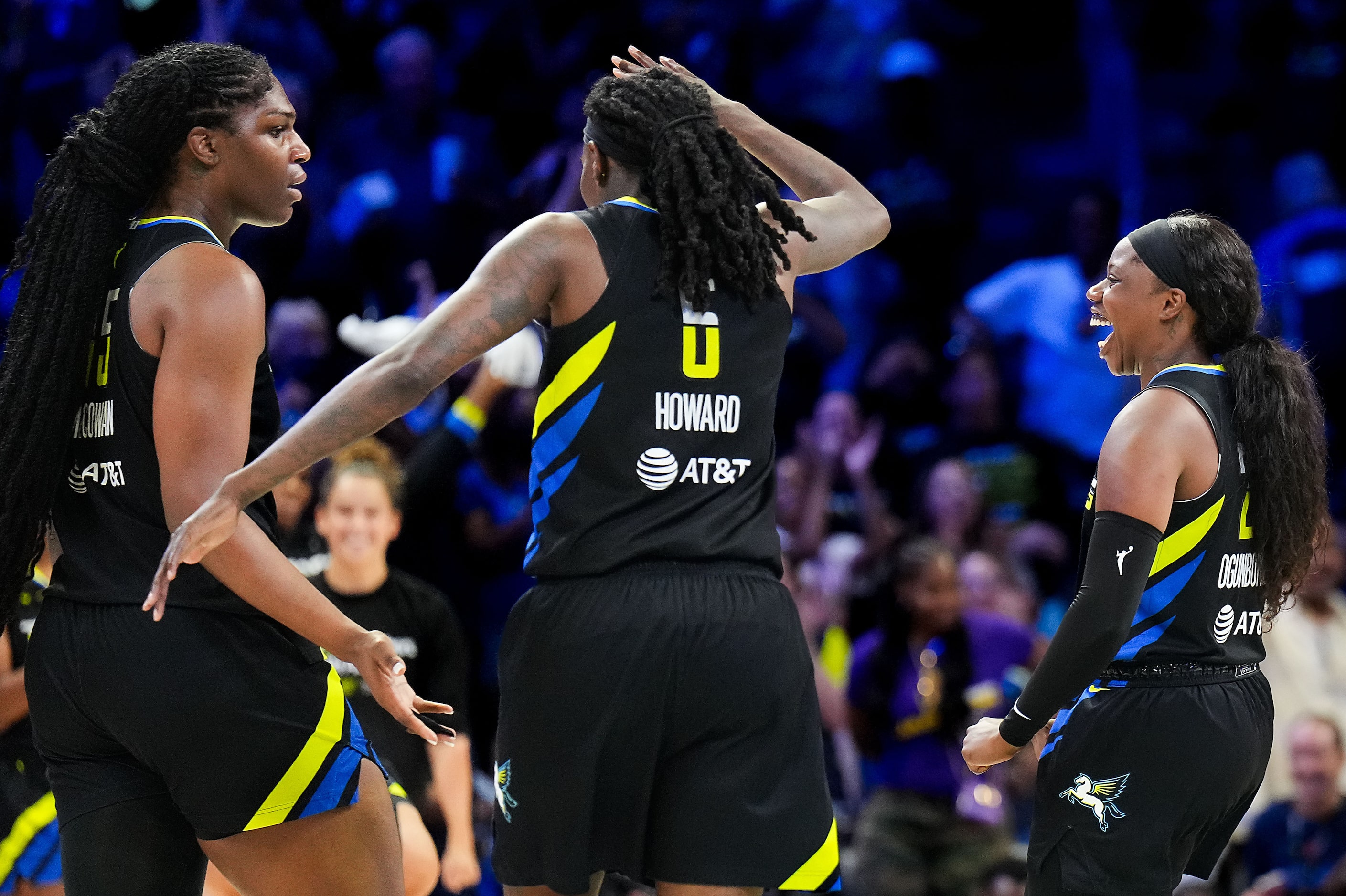 Dallas Wings center Teaira McCowan (left) celebrates with forward Natasha Howard (6) and...