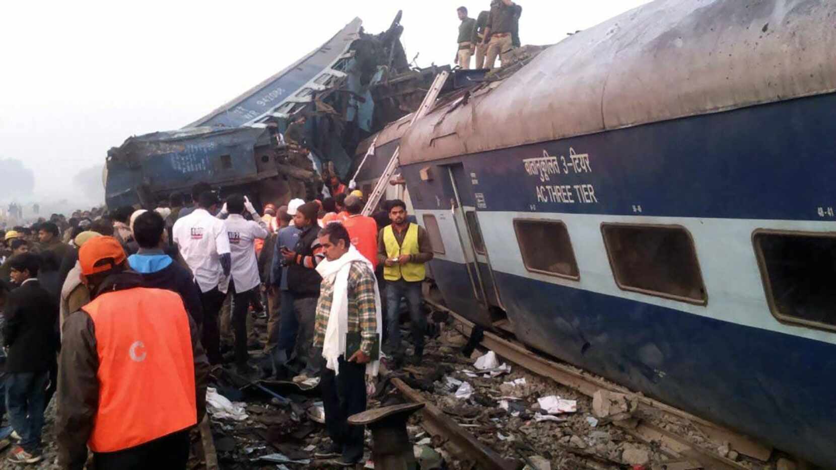 Indian rescue workers search for survivors in the wreckage of a train that derailed near...