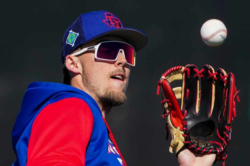 Outfielder outfielder Evan Carter makes a catch in a defensive drill during a Texas Rangers...
