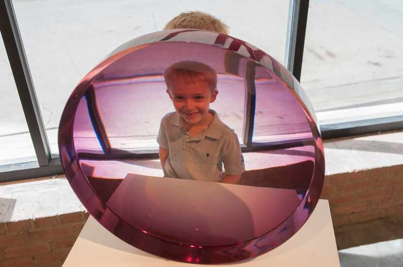
Barrett Gibbins, 7, peers through a cast and polished polyester piece by Fred Eversley...