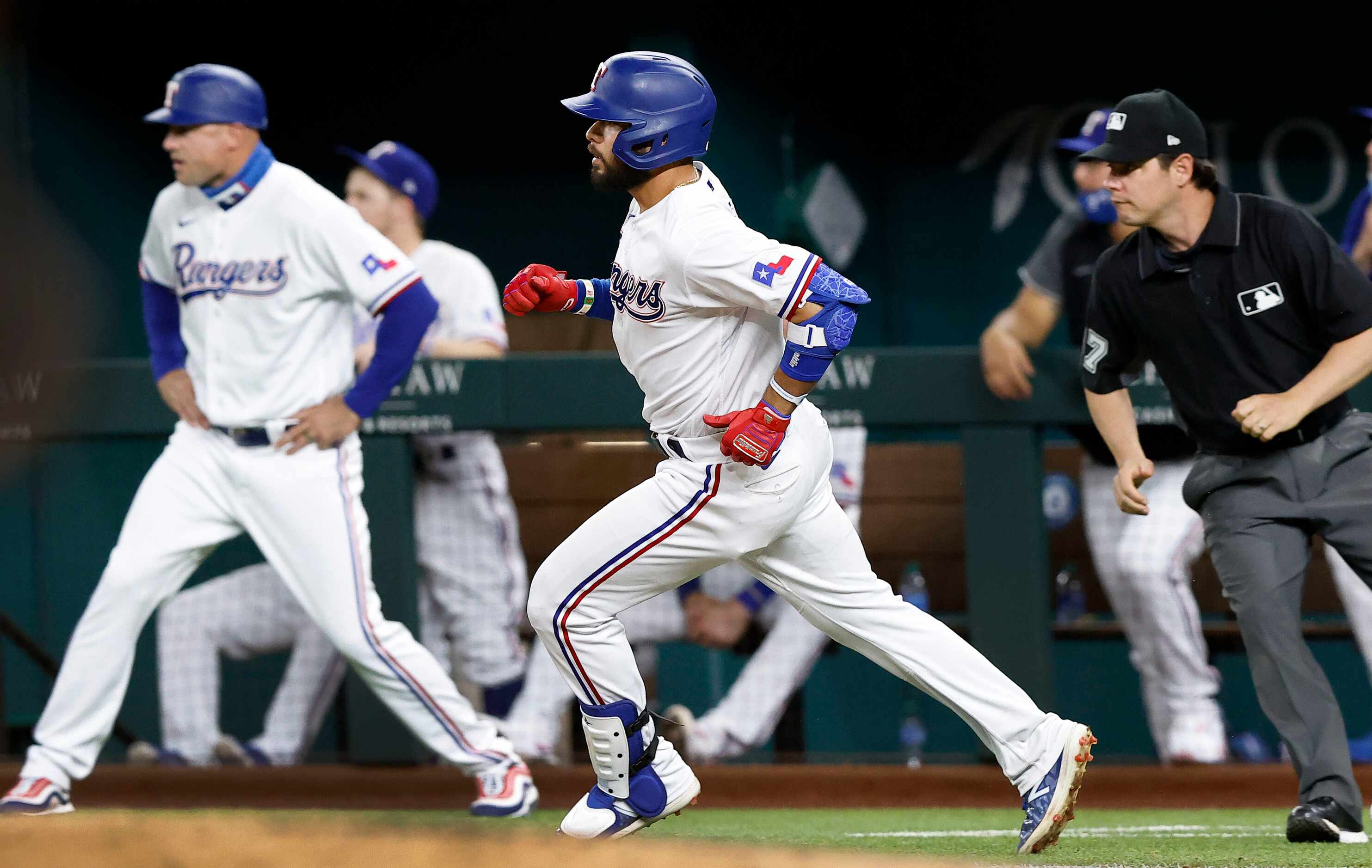 Texas Rangers Isiah Kiner-Falefa (center) watches his solo home run off of Boston Red Sox...