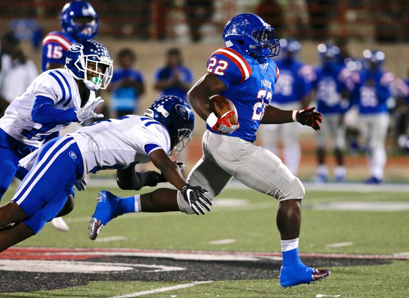 FILE - Grand Prairie junior defensive back Reggie Williams (5), center, tackles Duncanville...