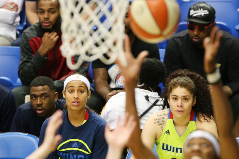 Dallas Wings guard Skylar Diggins (in warm up outfit) and center Amanda Zahui B (32) watch...