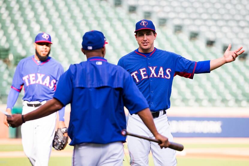 Texas Rangers starting pitcher Derek Holland laughts with third base coach Tony Beasley...