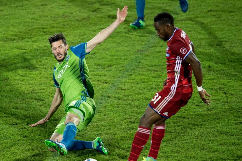 Seattle Sounders defender Brad Evans (3) slides in on FC Dallas defender Maynor Figueroa...