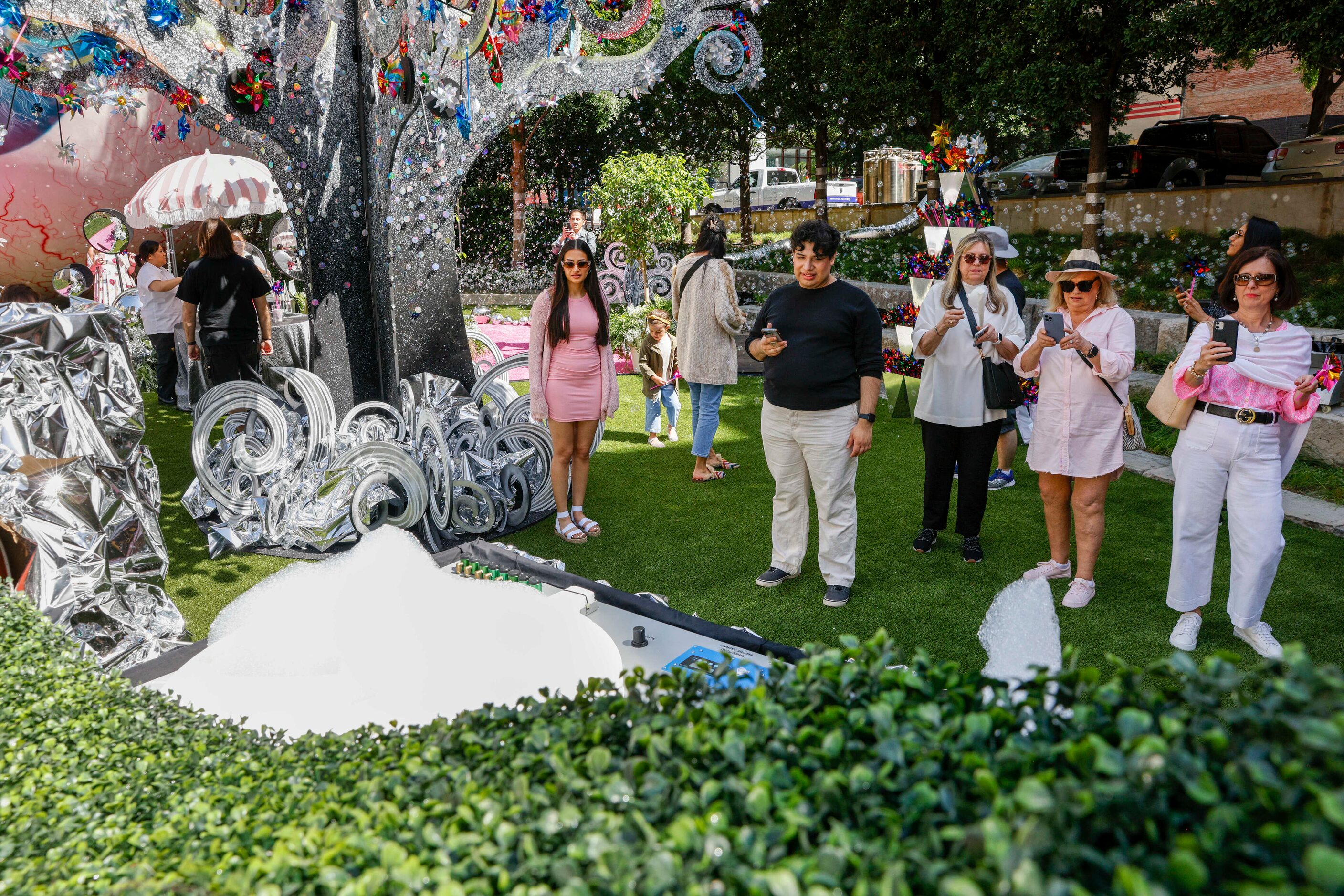 People take photos of a machine that makes bubbles in the shape of a butterfly and the state...