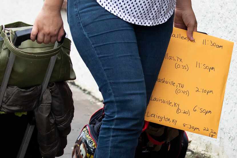 A woman carries an envelope marked with bus times as she heads from the bus station to the...