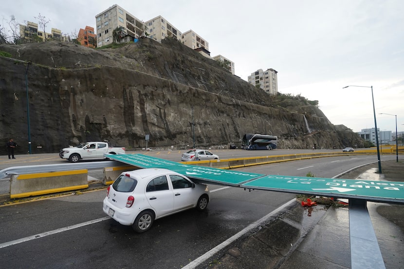 Una señalización de tránsito cayó sobre un vehículo por el paso del huracán Otis en...