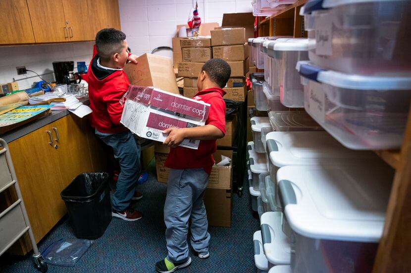Students help moves boxes of books and supplies in the library at the new Walnut Hill...