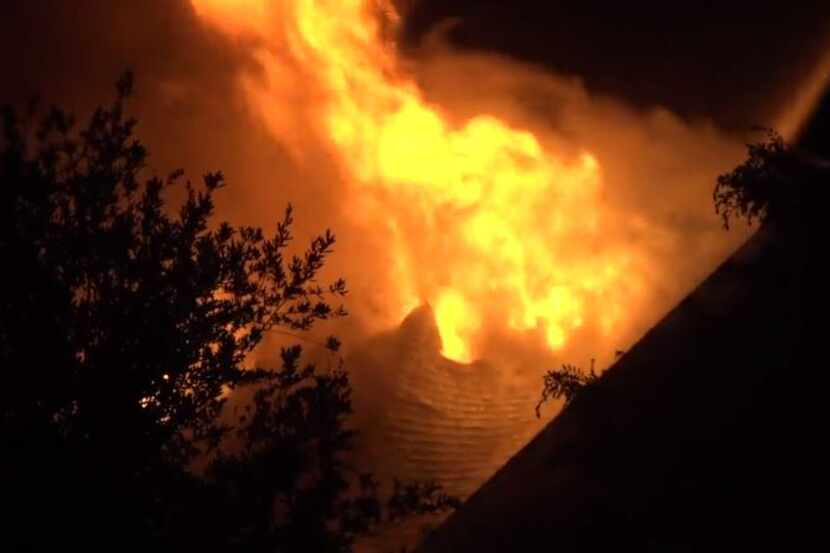 Fire burns through the roof of a home in Keller on Wednesday morning. Lightning was...