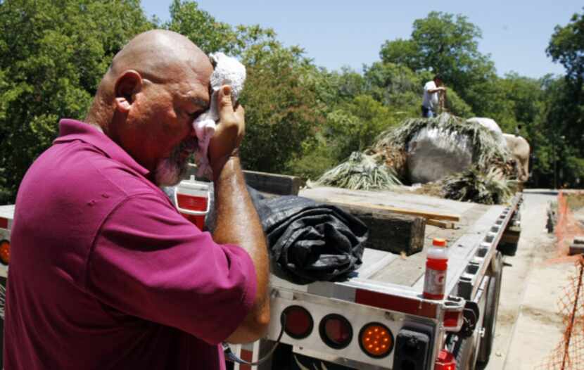 Alex Ybarra wipes the sweat from his face  in the 1100 block of Kessler Parkway in Dallas on...