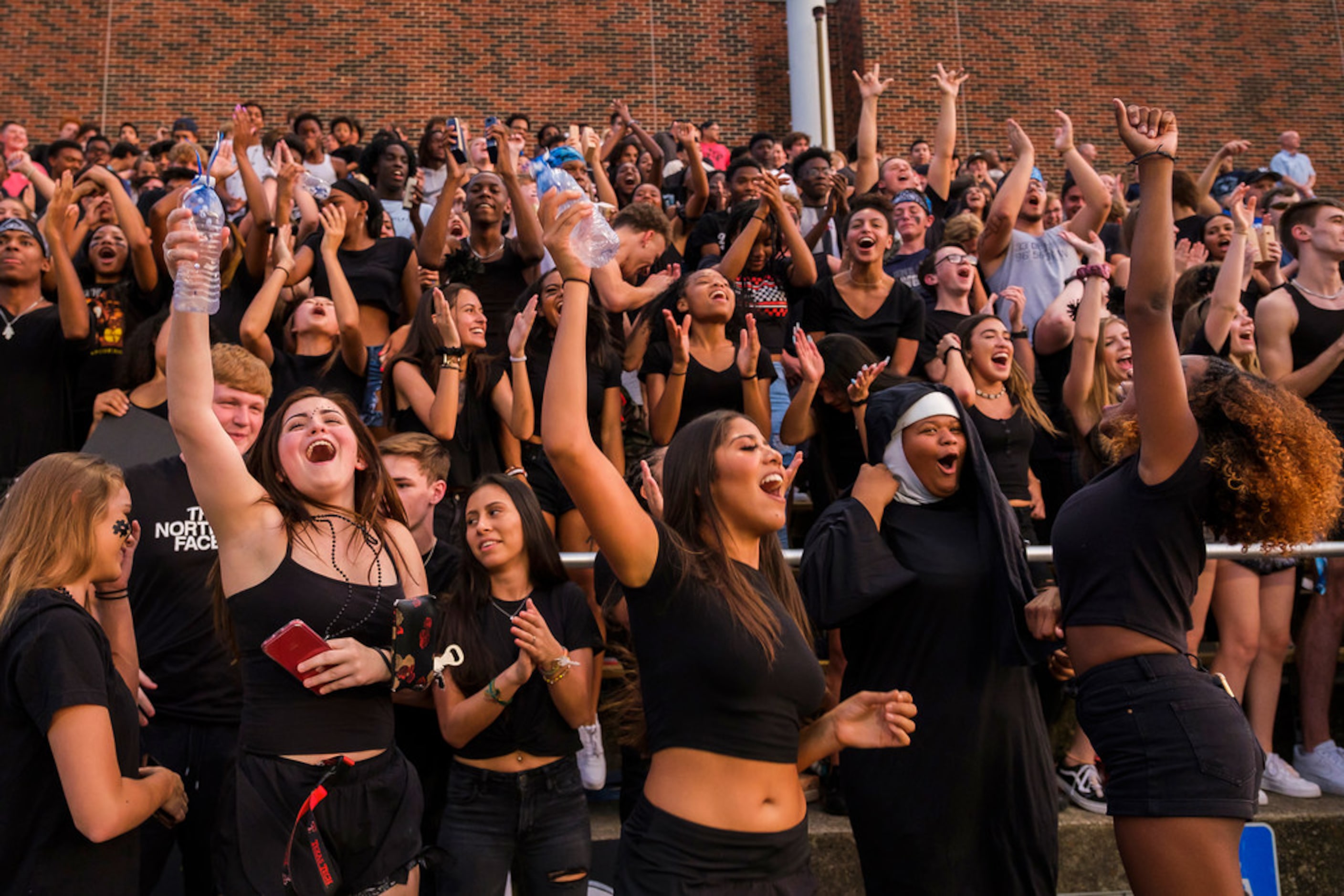 Frisco Lone Star fans cheer their team during the first half of a high school football game...