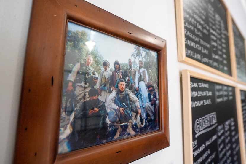 A photo of Brandon Friedman, top left, with Afghan militiamen hangs next to the chalkboard...