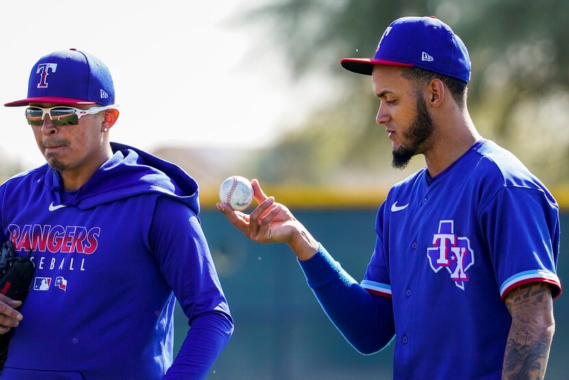 Texas Rangers pitchers Jonathan Hernandez (right) and Jesse Chavez walk between drills...