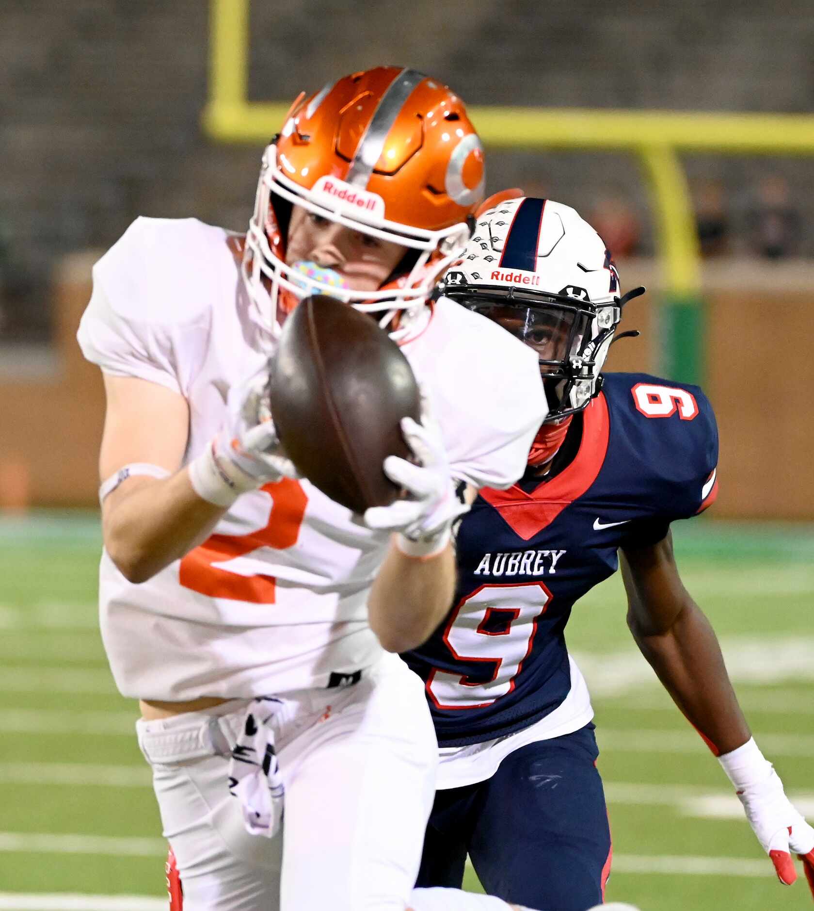 Celina's Collin Urich (2) catches a pass in front of Aubrey's Kamron Fields (9) in the first...