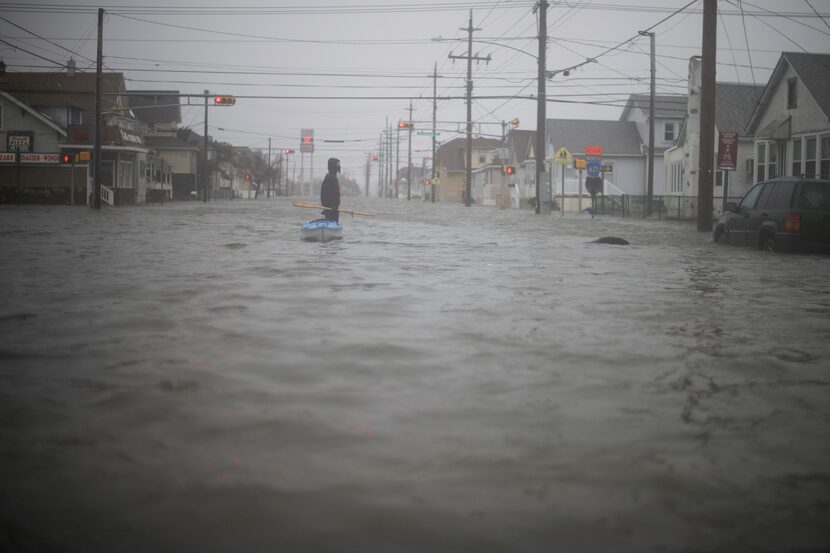  A man walks his kayak home through flooded streets in Wildwood, N.J., Jan. 23, 2016. (Mark...