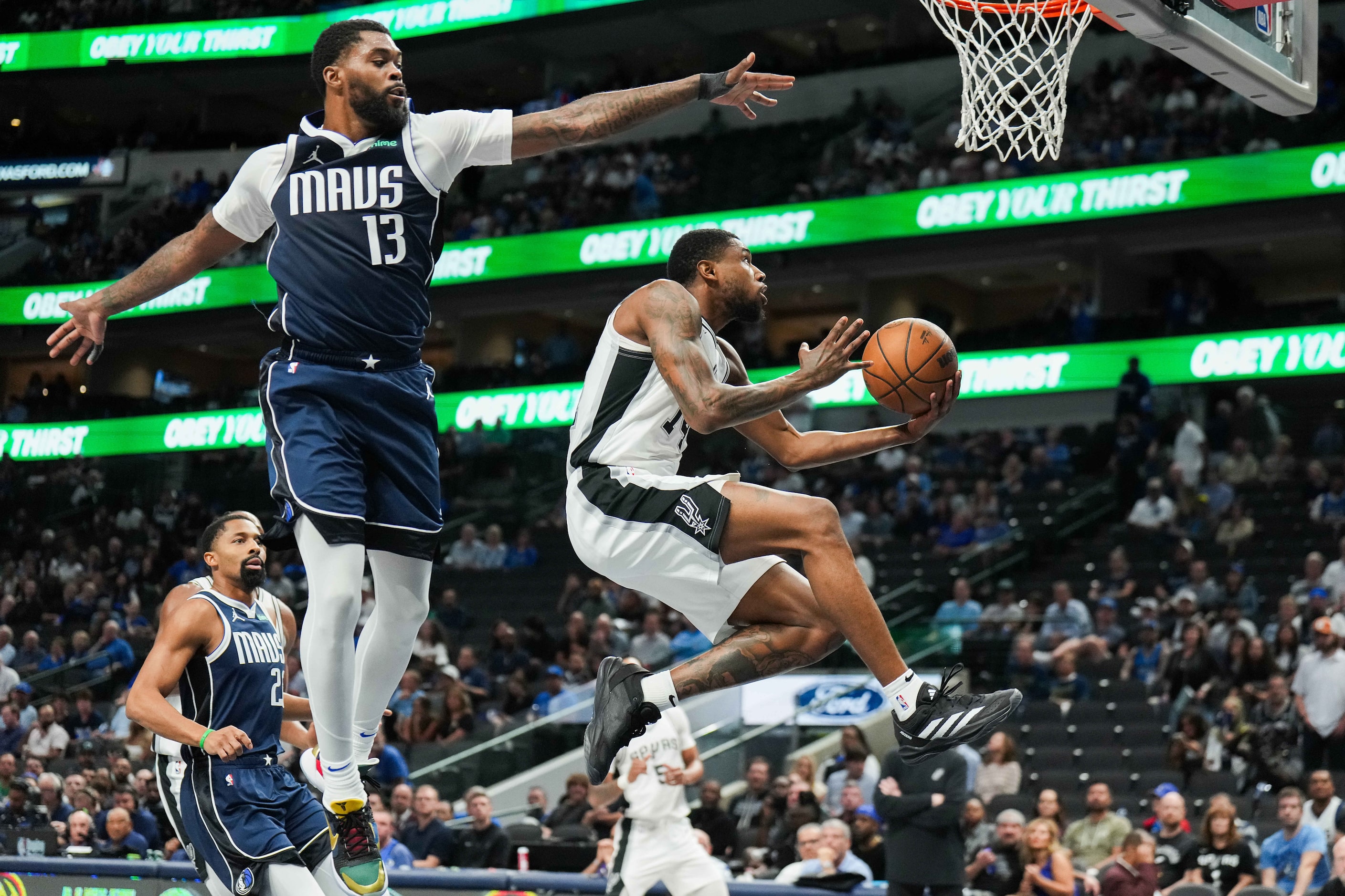 San Antonio Spurs guard Blake Wesley (14) drives past Dallas Mavericks forward Naji Marshall...