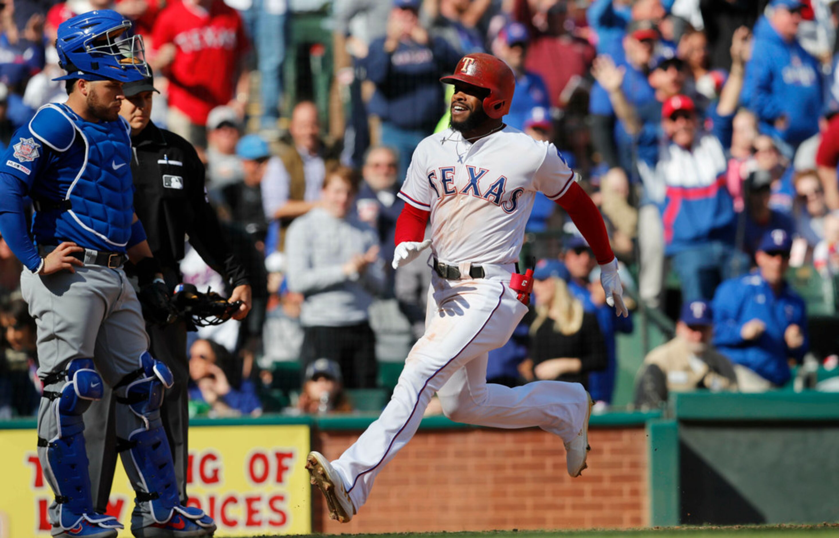 Texas Rangers' Delino DeShields, right, crosses home plate with Chicago Cubs catcher Victor...