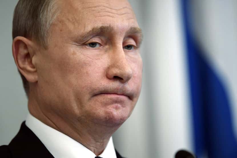 Russian President Vladimir Putin, left, reacts during a joint media conference with Finnish...