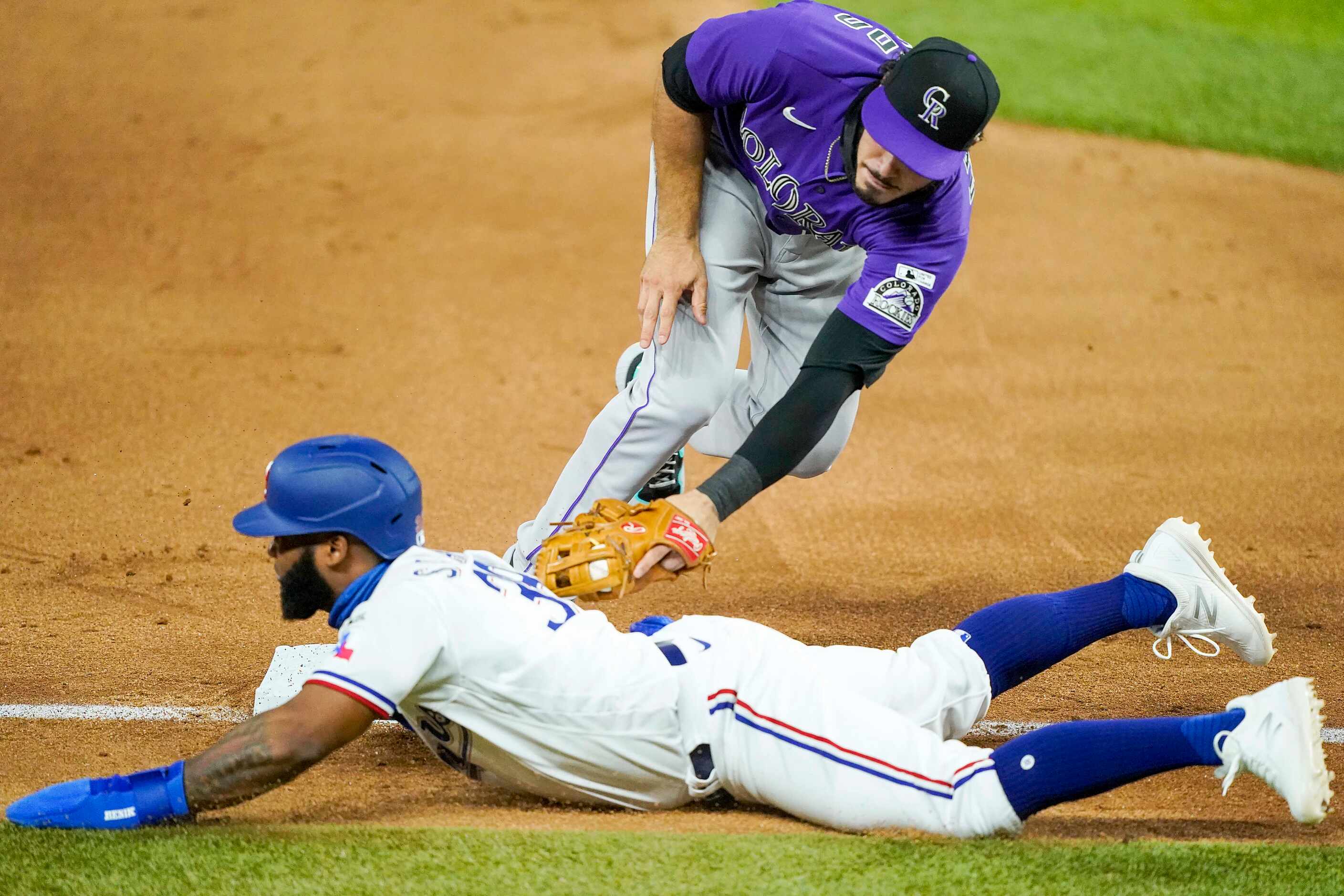 Texas Rangers outfielder Danny Santana gets back to the bag under the tag from Colorado...