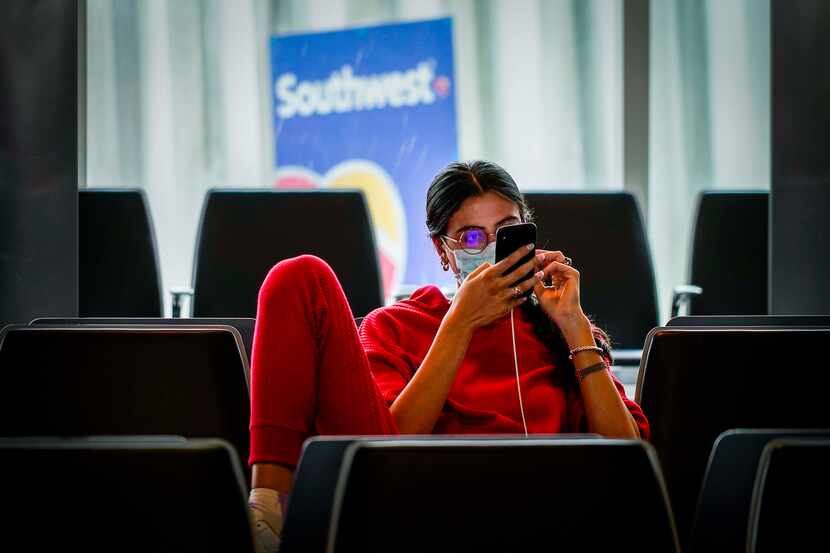 A passenger wearing a face mask due to the new coronavirus waits to board a Southwest...
