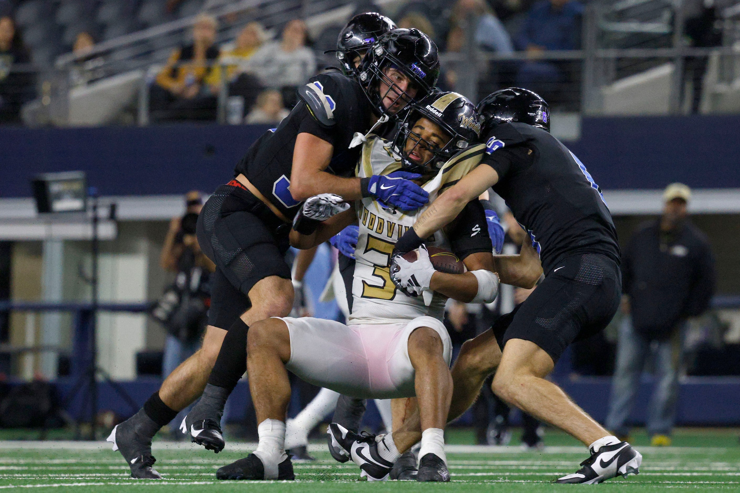 Woodville's Tayvion Hunter (3) is tackled by Gunter's Hayden Farrell (33), left, and...