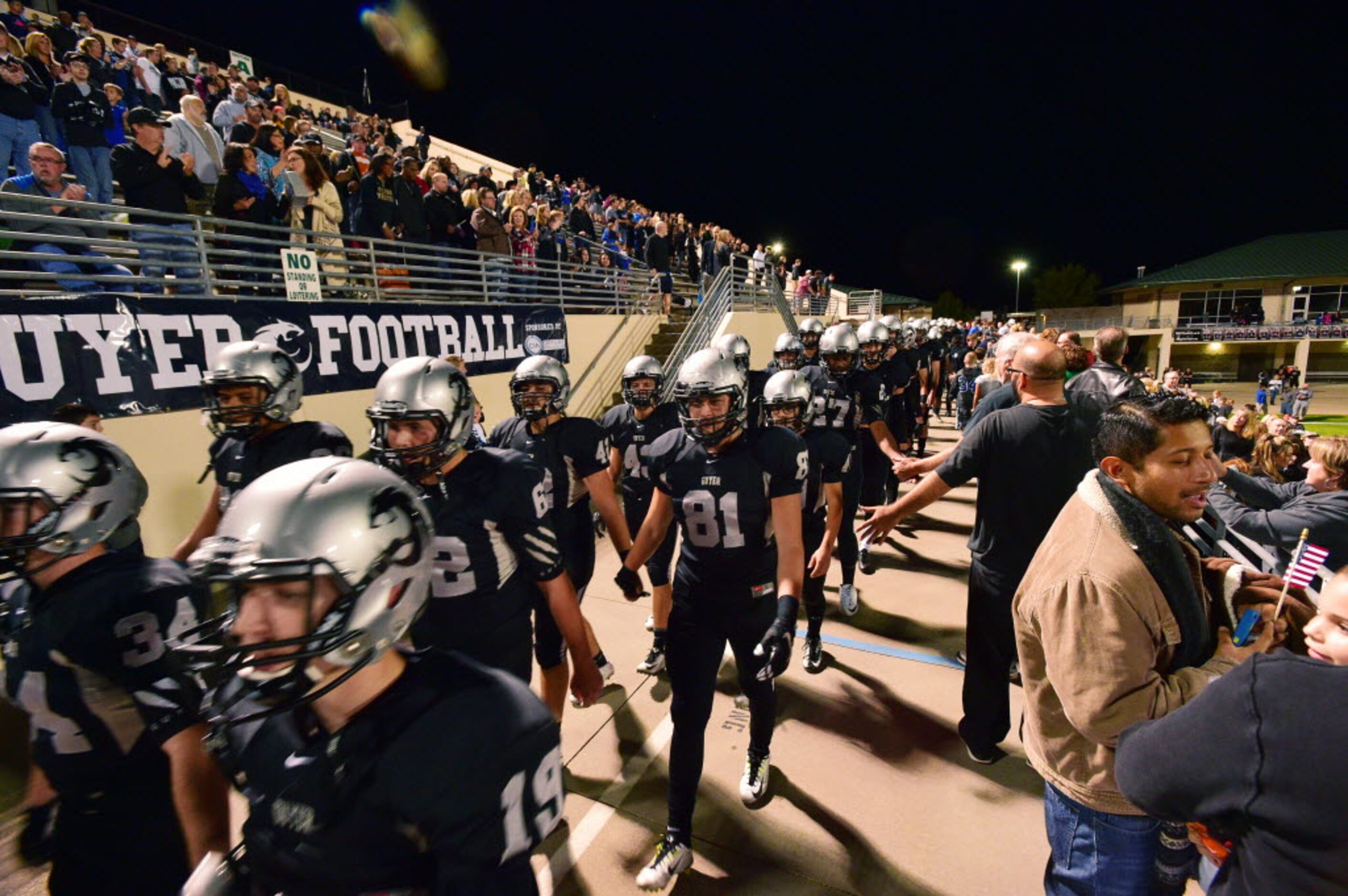 The Guyer Wildcats walk through the stands before taking the field against Ryan, Friday,...