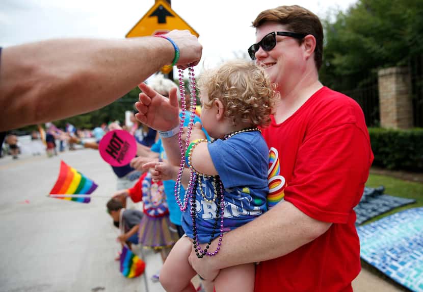Griffin McFerrin-Hogan, 1, was in prime position to be draped with beads as mom Laura...
