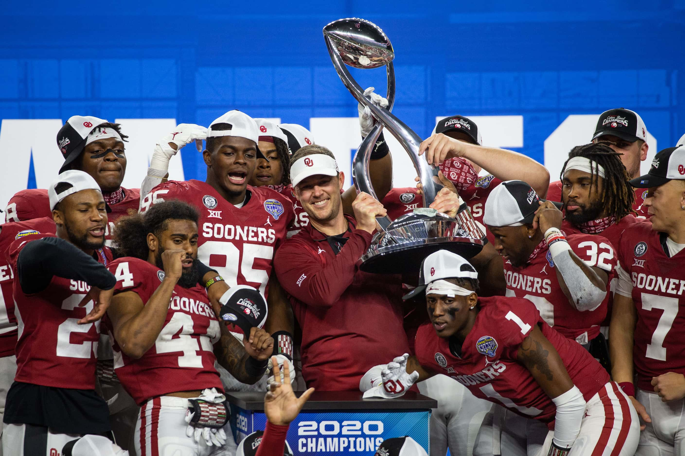 Oklahoma Sooners head coach Lincoln Riley holds up the Cotton Bowl champions’ trophy and...