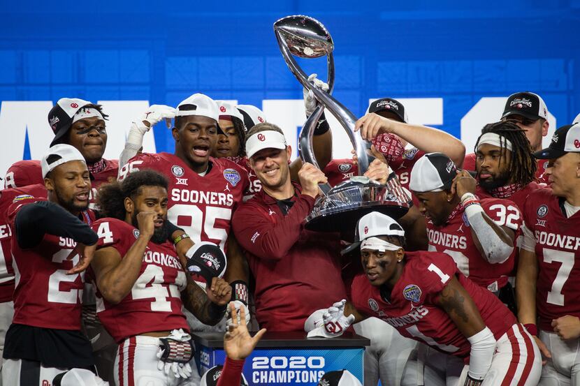 Oklahoma head coach Lincoln Riley holds up the Cotton Bowl champions’ trophy and celebrates...