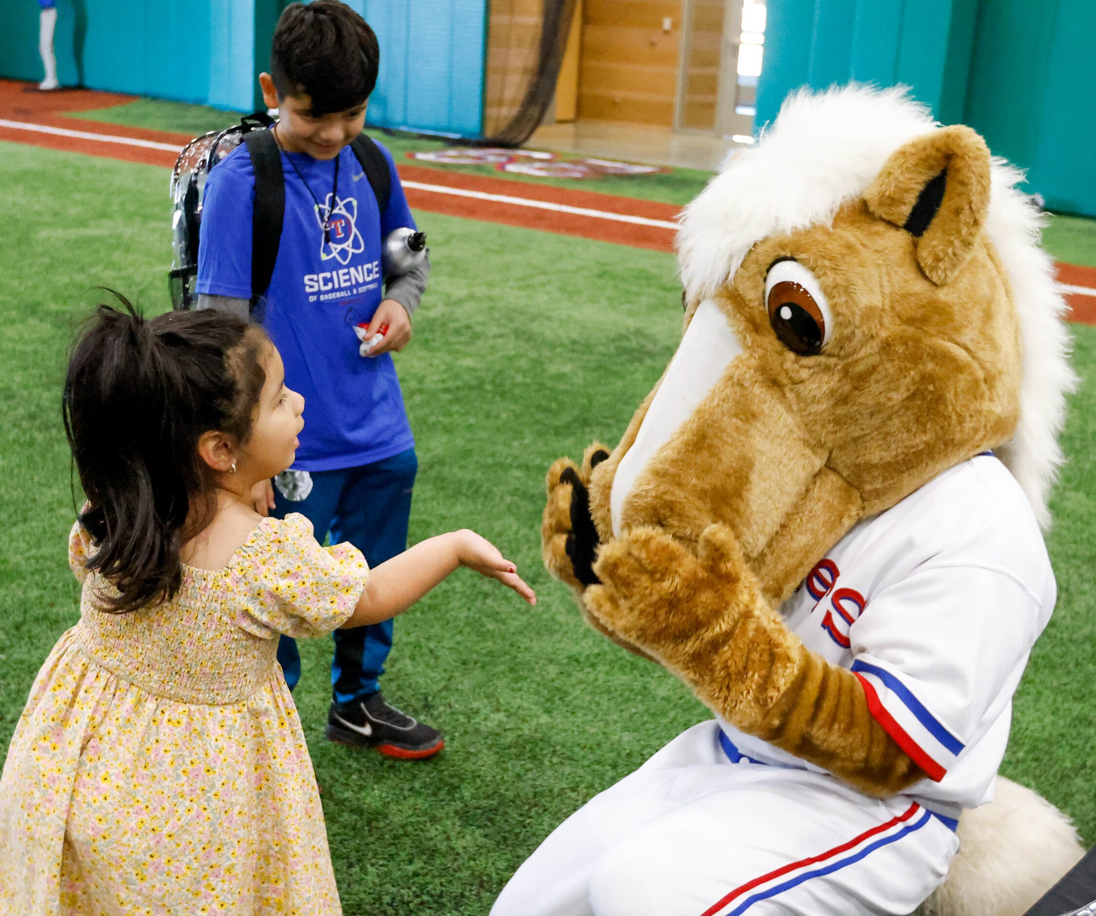 Litzy Pineda (left) blows a kiss to Texas Rangers mascot Captain as Andrew Garcia, 9, reacts...