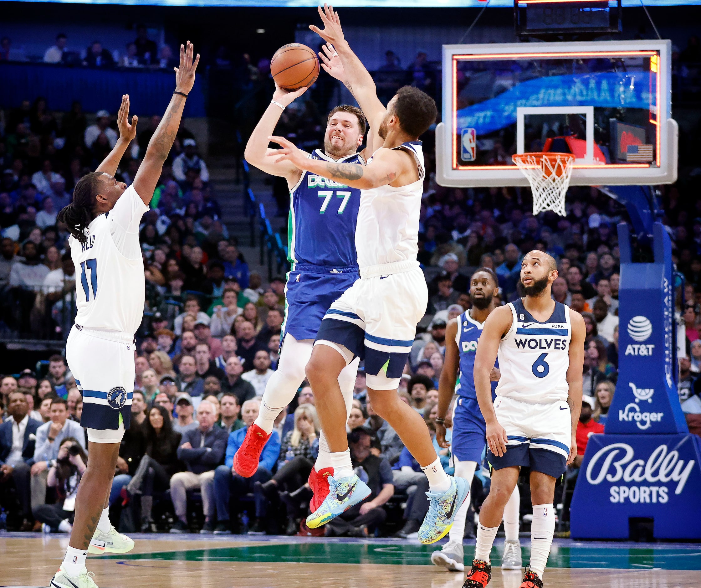 Dallas Mavericks guard Luka Doncic (77) puts up a nearly half court shot over Minnesota...