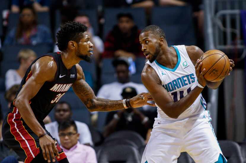 Charlotte Hornets forward Michael Kidd-Gilchrist, right, looks to drive against Miami Heat...