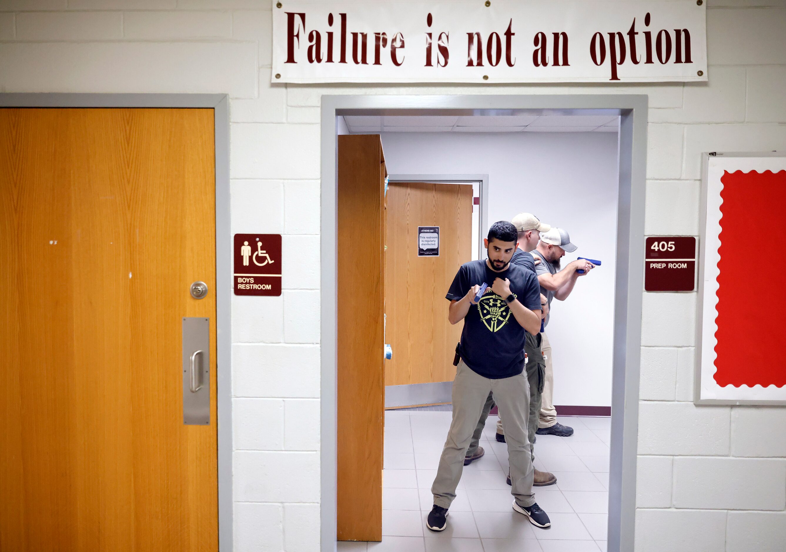 Henderson County Sheriff’s Deputy Sam Addkison covers the door as a three-person team sweeps...