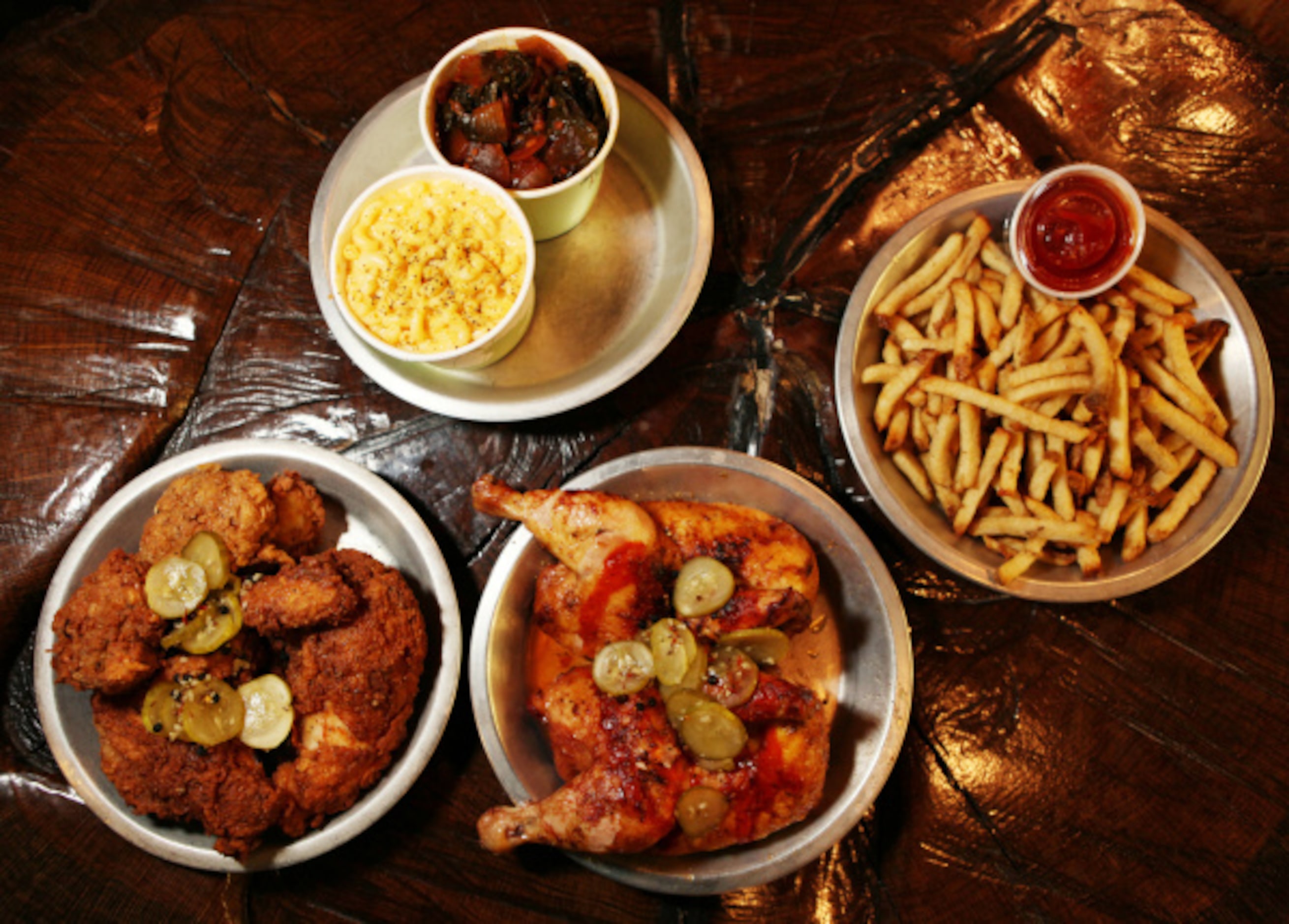 Clockwise from bottom left: fried chicken; mac and cheese; collard greens; fries with...