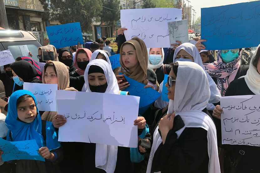 FILE - Afghan women chant and hold signs of protest during a demonstration in Kabul,...