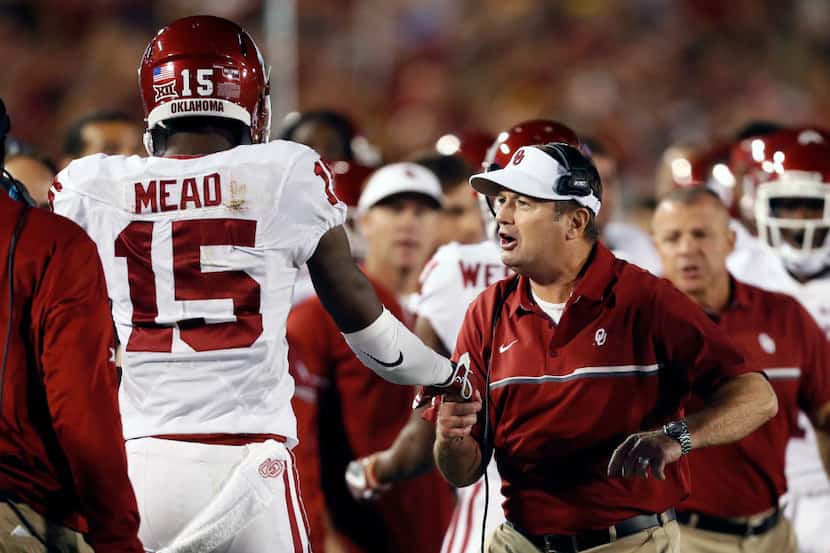 Oklahoma wide receiver Jeffery Mead (15) celebrates with head coach Bob Stoops, right, after...