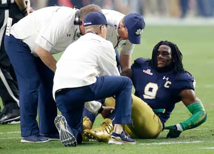 In this Jan. 1, 2016, file photo, Notre Dame linebacker Jaylon Smith (9) is attended to...
