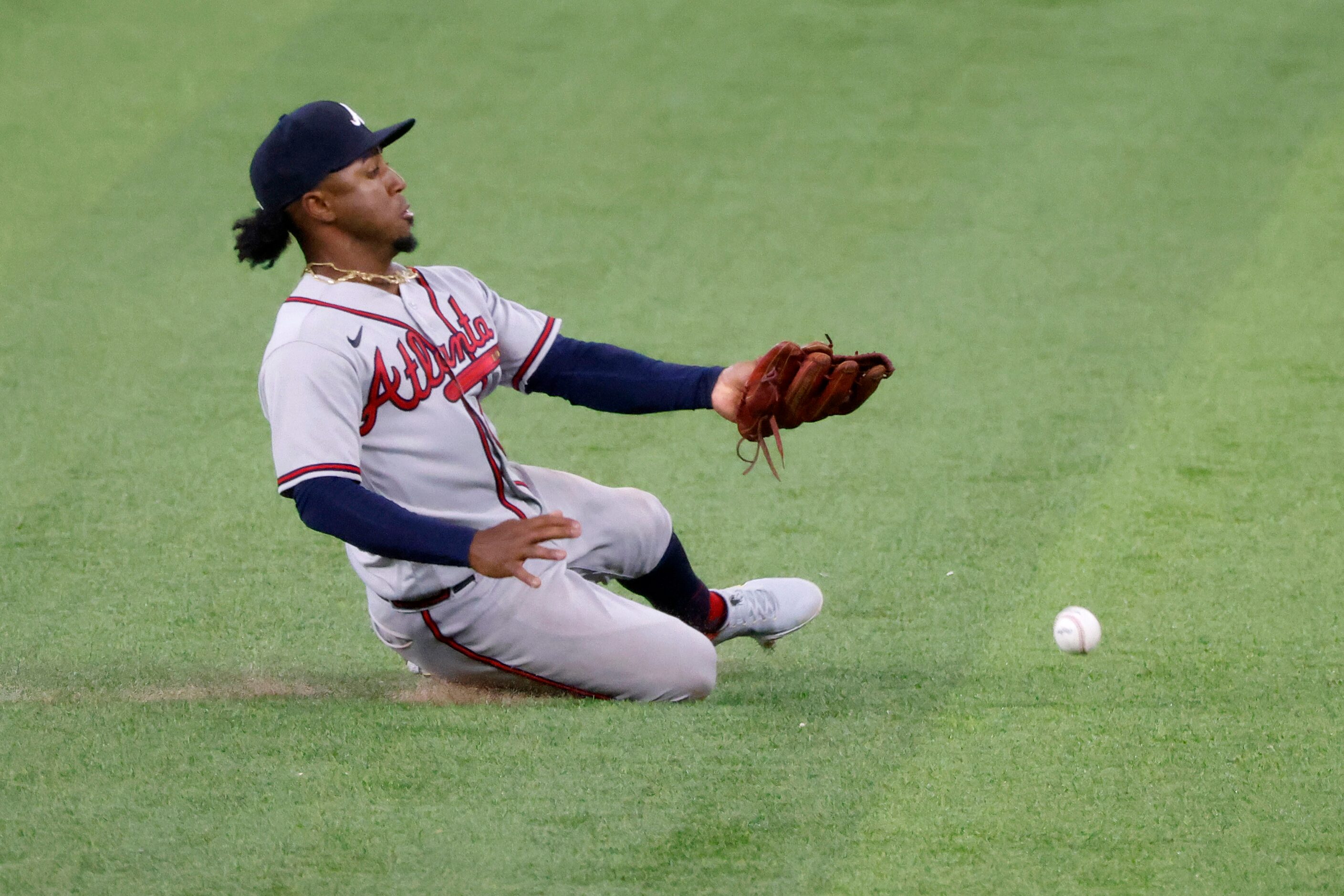 Atlanta Braves second baseman Ozzie Albies fails to catch a ball off the bat of Texas...