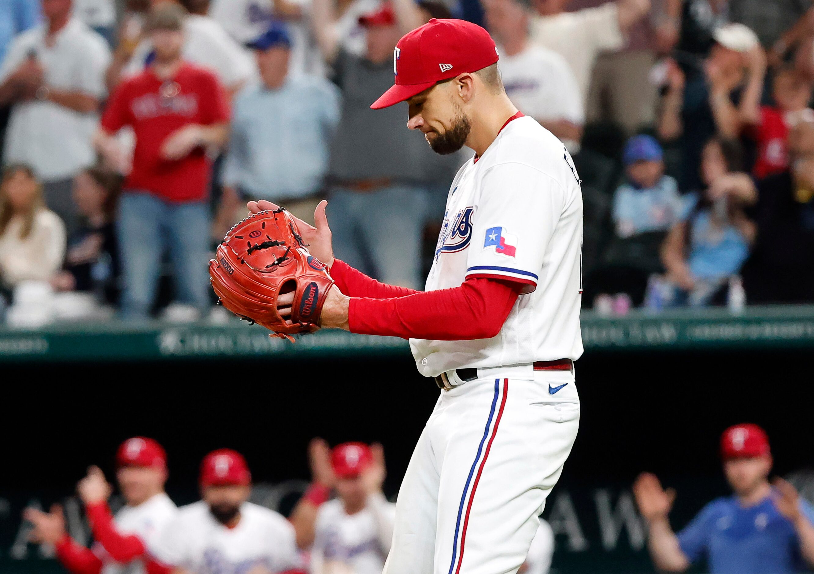 Texas Rangers starting pitcher Nathan Eovaldi (17) reacts after watching the final out of...