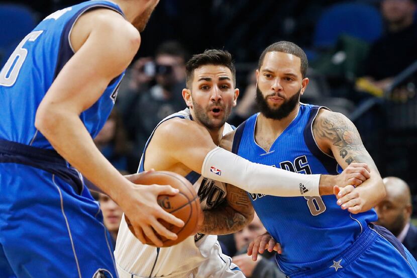 Minnesota Timberwolves' Ricky Rubio, center attempts to keep Dallas Mavericks' Deron...