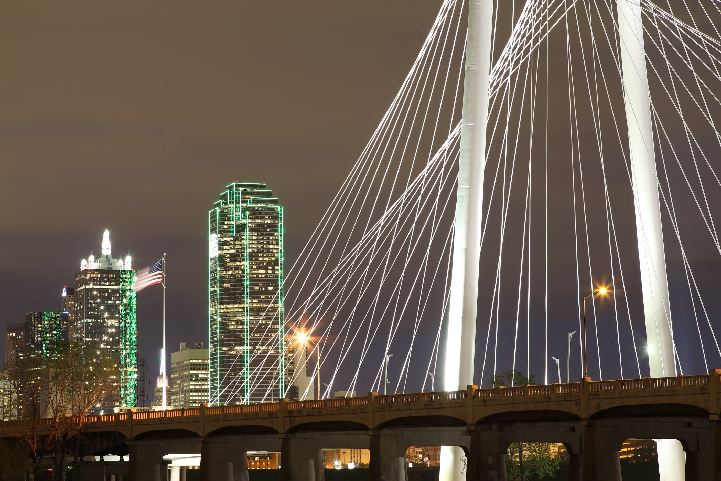 Margaret Hunt Hill Bridge against the Dallas skyline at night by Bobby LaJoie