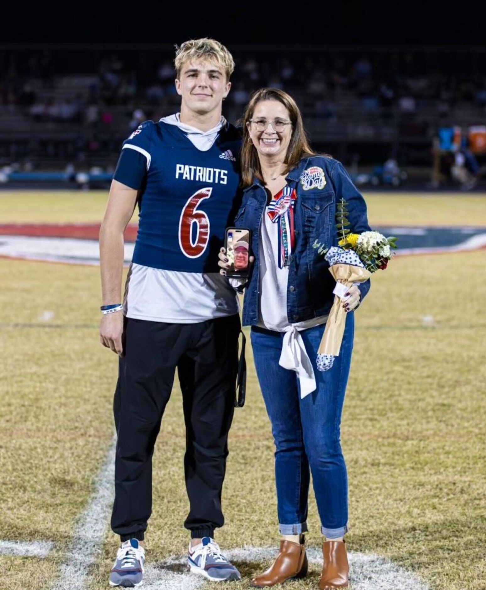 Mike Elko's wife, Michelle, and their son, Andrew. Mike Elko's face is seen on Micelle's...