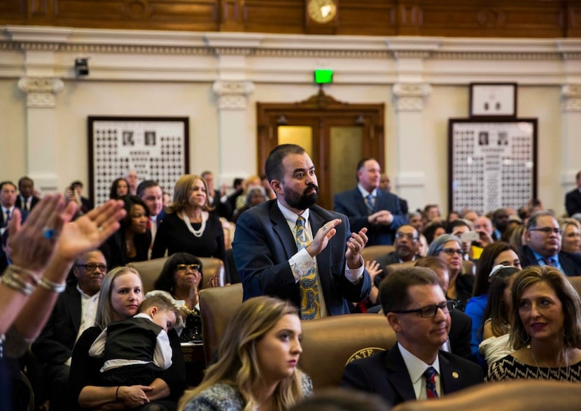 Rep. Joe Moody and other representatives applaud as Rep. Joe Straus, not pictured, is...