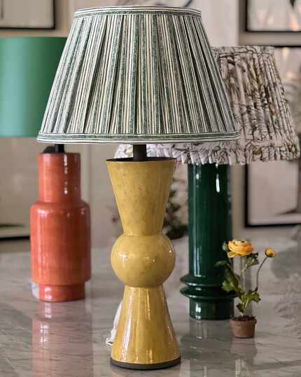 Three lamps in yellow, green and orange have a variety of shade styles including a pleated...