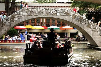 A guided barge trip cruises toward the popular restaurant area along the San Antonio River...